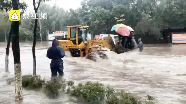 哈尔滨路面积水铲车运送市民10元一位……